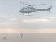 helicopter taking off with SkyTEM rig at sunrise