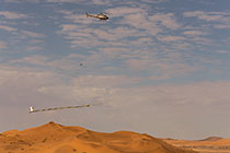 helicopter flying with SkyTEM rig over sand dunes