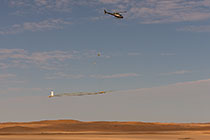 helicopter flying with SkyTEM rig over sand dunes