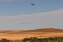 helicopter flying with SkyTEM rig over sand dunes