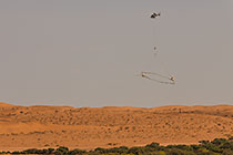 helicopter flying with SkyTEM rig over sand dunes
