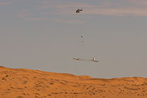 helicopter flying with SkyTEM rig over sand dunes