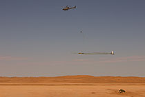 helicopter flying with SkyTEM rig over sand dunes