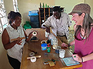 lady explaing bead making to Elias & Lisa