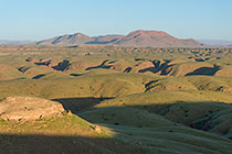 hills covered with grass at sunset