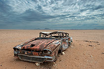 old rusted cadilac car in desert plain