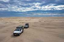 ranger-camper & disco driving through sandy desert