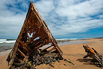 rusted shipwreck on ocean seashore