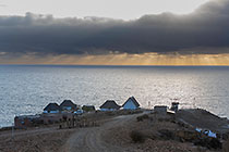 lodge & cabin on ocean seashore at sunset