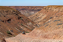 disco driving down on rocky track through arid canyon