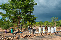 children selling charcoal bags along road