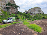 Lisa & ranger-camper at campsite near huge granite boulders between green vegetation