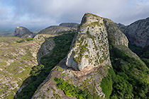 huge granite boulders between green vegetation in clouds