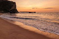 brocken ponton in sea & cliff at sunset