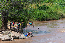 people bathing & washing clothes in river
