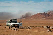 ranger camper in arid plain under mist at sunrise