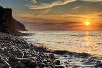 stony beach & cliff at sunset