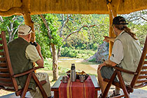 Ibandla house : guests having coffee on deck & watching to river