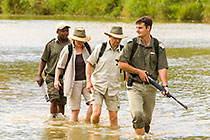 ranger, guests & tracker crossing river barefoot