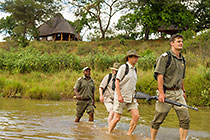 ranger, guests & tracker crossing river barefoot + Ibandla house