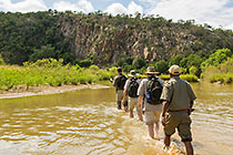 ranger, guests & tracker crossing river barefoot