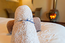 standard cottage : towels on bed & fireplace